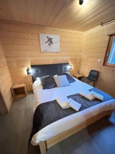 Chalet des Cîmes, chaleureux avec jacuzzi et sauna في جوراردُميه: غرفة نوم بسرير كبير في غرفة خشبية
