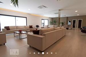 uma grande sala de estar com sofás e mesas em Flat luxo, mobiliado c/ ar, wi-fi, pisc. e academia em Barueri