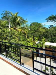 einen Balkon mit einem schwarzen Zaun und Bäumen in der Unterkunft Villa Linda in Doradal