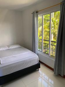 ein Schlafzimmer mit einem Bett und einem großen Fenster in der Unterkunft Villa Linda in Doradal