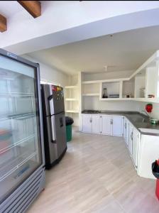 eine Küche mit weißen Schränken und einem Kühlschrank aus Edelstahl in der Unterkunft Villa Linda in Doradal