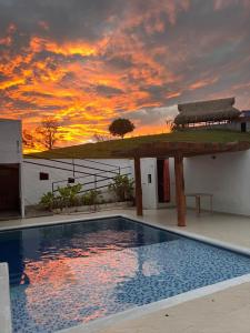 eine Villa mit einem Pool vor einem Sonnenuntergang in der Unterkunft Villa Linda in Doradal