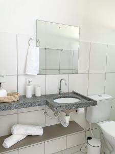 マレシャウ・デオドーロにあるCasa Iva - Condomínio Fechadoの白いバスルーム(シンク、鏡付)