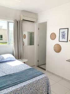 a white bedroom with a bed and a window at Casa Iva - Condomínio Fechado in Marechal Deodoro
