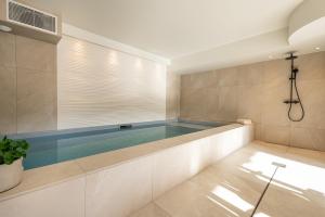 a large swimming pool in a room with a tub at CHALET LA MANIGODINE Piscine 18-24 pers in Manigod +60 photos