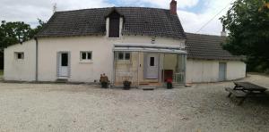 Biały dom z ławką przed nim w obiekcie Gîte Chez Jeannot w mieście Azay-le-Ferron