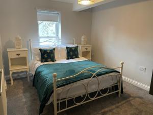 a bedroom with a bed with a green comforter at Cosy two bedroom apartment in Bishop Auckland