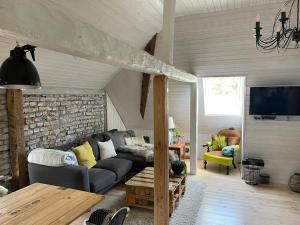 Tiny House Ostsee # Naturwerk في Pruchten: غرفة معيشة مع أريكة وتلفزيون