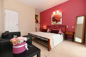 a bedroom with a bed and a couch and a mirror at MS Resort in Nemėžis