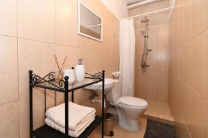 y baño con aseo, lavabo y ducha. en MS Resort en Nemėžis