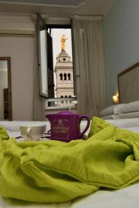 ローマにあるホテル アナカプリのベッド(緑の毛布、カップ付)