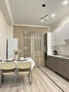 a kitchen with a table and chairs in a room at Apartments GREEN PLAZA с видом на море in Aktau