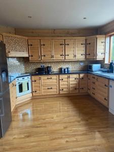 cocina con armarios de madera y suelo de madera en Fern Lodge. Drumcoura Lake Resort, en Ballinamore