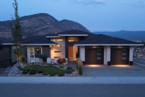 une grande maison avec une montagne en arrière-plan dans l'établissement Black Mountain Amazing Home on Golf Course, à Kelowna