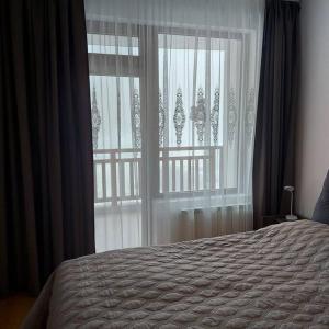 a bedroom with a bed and a large window at Семи гарден in Borovets