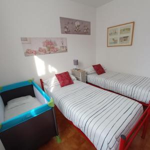 Appartamento incantevole a Sestola في سيستولا: سريرين توأم في غرفة بجدران بيضاء