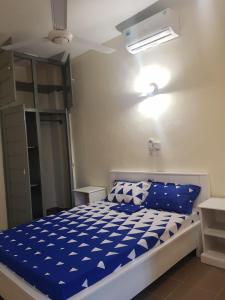 Schlafzimmer mit einem Bett mit blauer und weißer Bettwäsche in der Unterkunft Bel appartement au centre ville de calavi BENIN in Abomey-Calavi