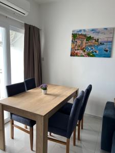 a dining room table with blue chairs and a painting at Tetris Apartment Spacious Comfortable in Lefkosa Turk