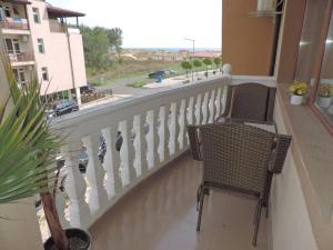 a balcony with two chairs and a view of a street at Частен апартамент Стамополу - Private Two-Bedroom Apartment Stamopolu in Primorsko