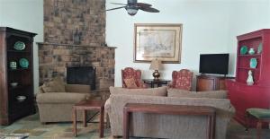 sala de estar con sofá y chimenea en Dogwood Springs Lodgings en Mineola