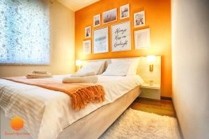 ein Schlafzimmer mit einem großen Bett und einer orangefarbenen Wand in der Unterkunft Sunset Vrnjačka Banja in Vrnjačka Banja