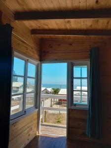 a room with two windows and a view of the beach at Martera in Constitución +8 photos