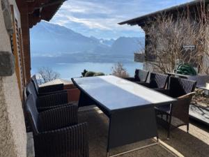 a table and chairs on a balcony with a view of the water at Wohnung in Sigriswil