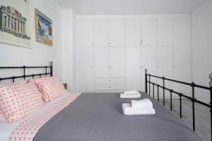 a bedroom with a bed with two towels on it at Psyris Marble Loft ! in Athens