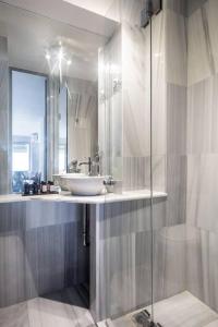 a bathroom with a sink and a glass shower at Psyris Marble Loft ! in Athens