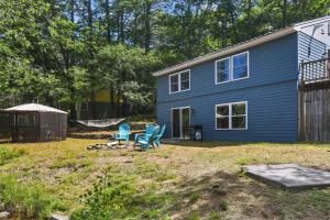 a blue house with chairs and a hammock in the yard at RANDALL LAKE RETREAT-LIMIT 7 villa 