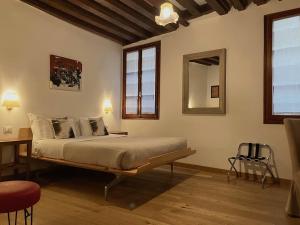 een slaapkamer met een bed, een tafel en een spiegel bij Residenza Corte Antica in Venetië