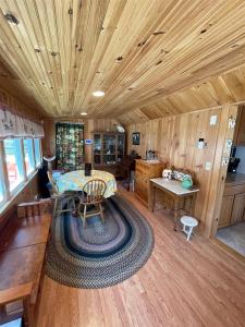 uma sala de estar com uma mesa e um tecto de madeira em ROCKY'S LAKE HOUSE-LIMIT 6 home em Standish