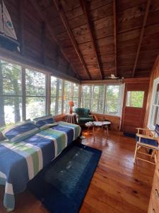 ein Schlafzimmer mit einem Bett in einem Zimmer mit Fenstern in der Unterkunft INGALL'S NOOK LIMIT 8 cabin in Bridgton