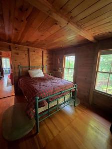 ein Schlafzimmer mit einem Bett in einem Blockhaus in der Unterkunft INGALL'S NOOK LIMIT 8 cabin in Bridgton