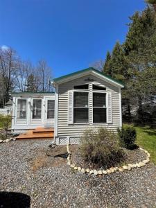 a small white house with a yard at SUNNY BREAK- LIMIT 6 cottage in Raymond