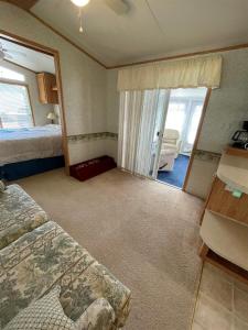 1 dormitorio con 1 cama y puerta corredera de cristal en SUNNY BREAK- LIMIT 6 cottage, en Raymond