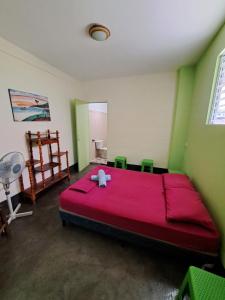 1 dormitorio con 1 cama roja en una habitación verde en Hostal Mochilas, en Granada