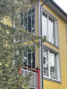 a yellow house with a red door and windows at Guest House Mr Fox in Druskininkai