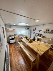 a kitchen with a wooden table in the middle of it at Patagonia Sweet Home in Puerto Natales