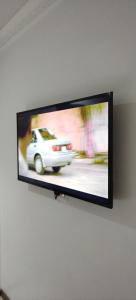 Telewizor wiszący na ścianie z samochodem w obiekcie Cheers w mieście Evander