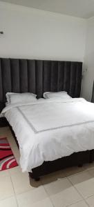 a large white bed with a black headboard in a room at Cheers in Evander