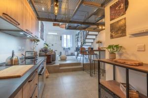 a kitchen and living room with a staircase in the background at Unique studio loft, walking distance to Valletta in Hamrun