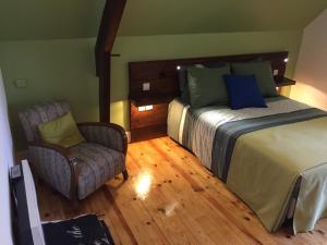 Habitación de hotel con cama y silla en Chambres d'hôtes MoulinDT, en Virazeil