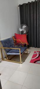 Habitación con silla azul y almohada roja en Cheers, en Evander