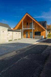 a large wooden house with a road in front of it at Apartmány Kopacka in Svitavy