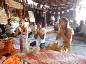 a group of people sitting on the floor praying at Tonle Mekong Homestay in Krong Kracheh