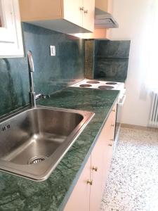 a kitchen with a sink and green counter top at EstellApartments in Athens