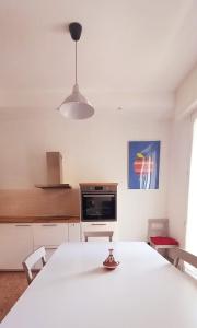 een keuken met een witte tafel met stoelen en een lamp bij Carachouse-Parma in Parma