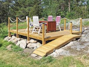 four chairs and a table on a wooden deck at 7 person holiday home in LUR in Lur