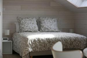 1 dormitorio con 1 cama con manta blanca y almohadas en Home Kervezec, en Garlan